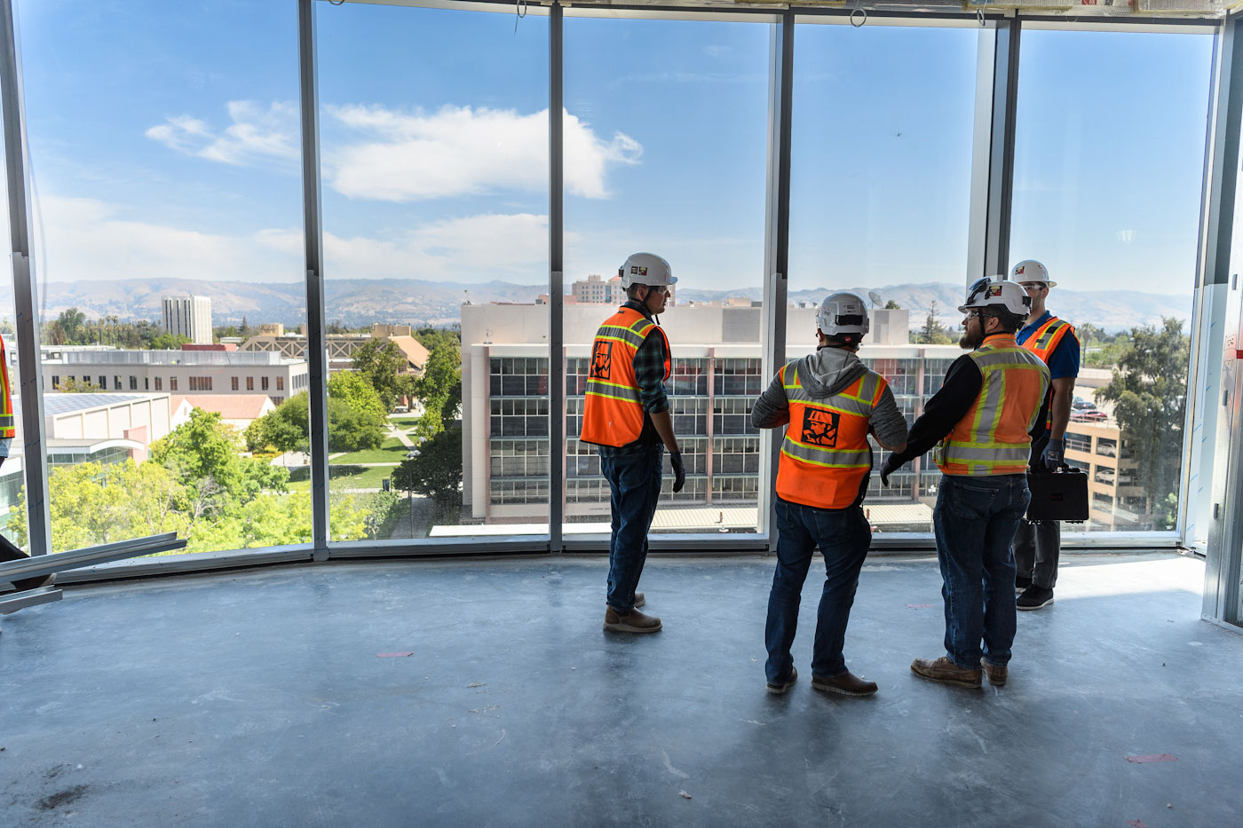 construction workers looking out from glass building