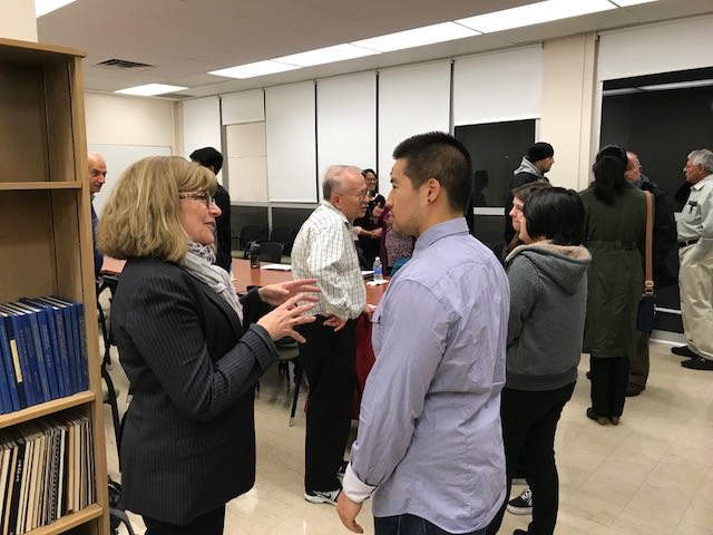 a faculty member talks with a student during an event