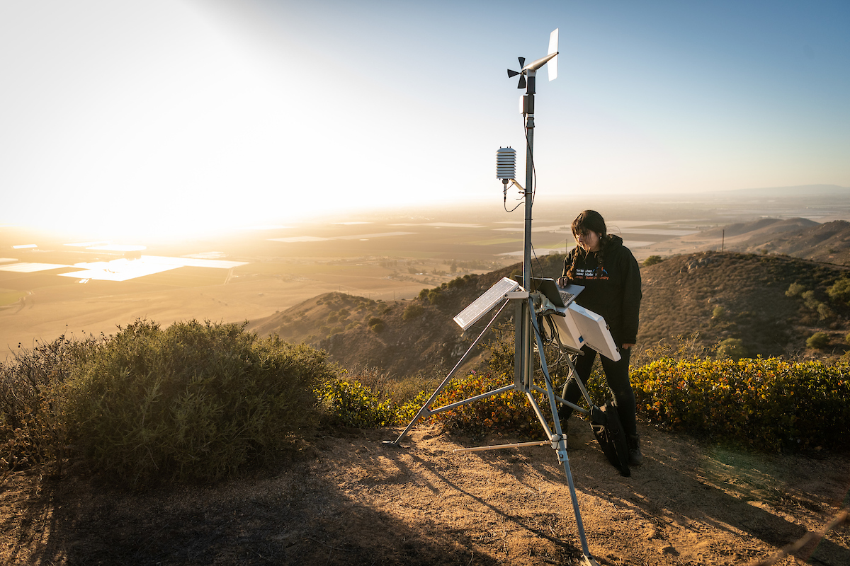 student with meterology machine in sunrise