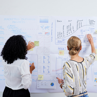 business executives analyzing charts and sticking memos over it
