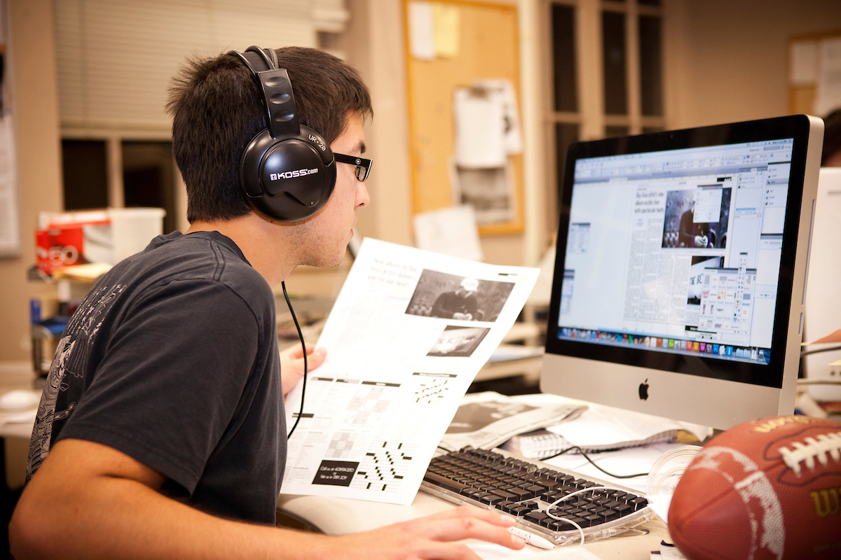 student on a computer and headphones