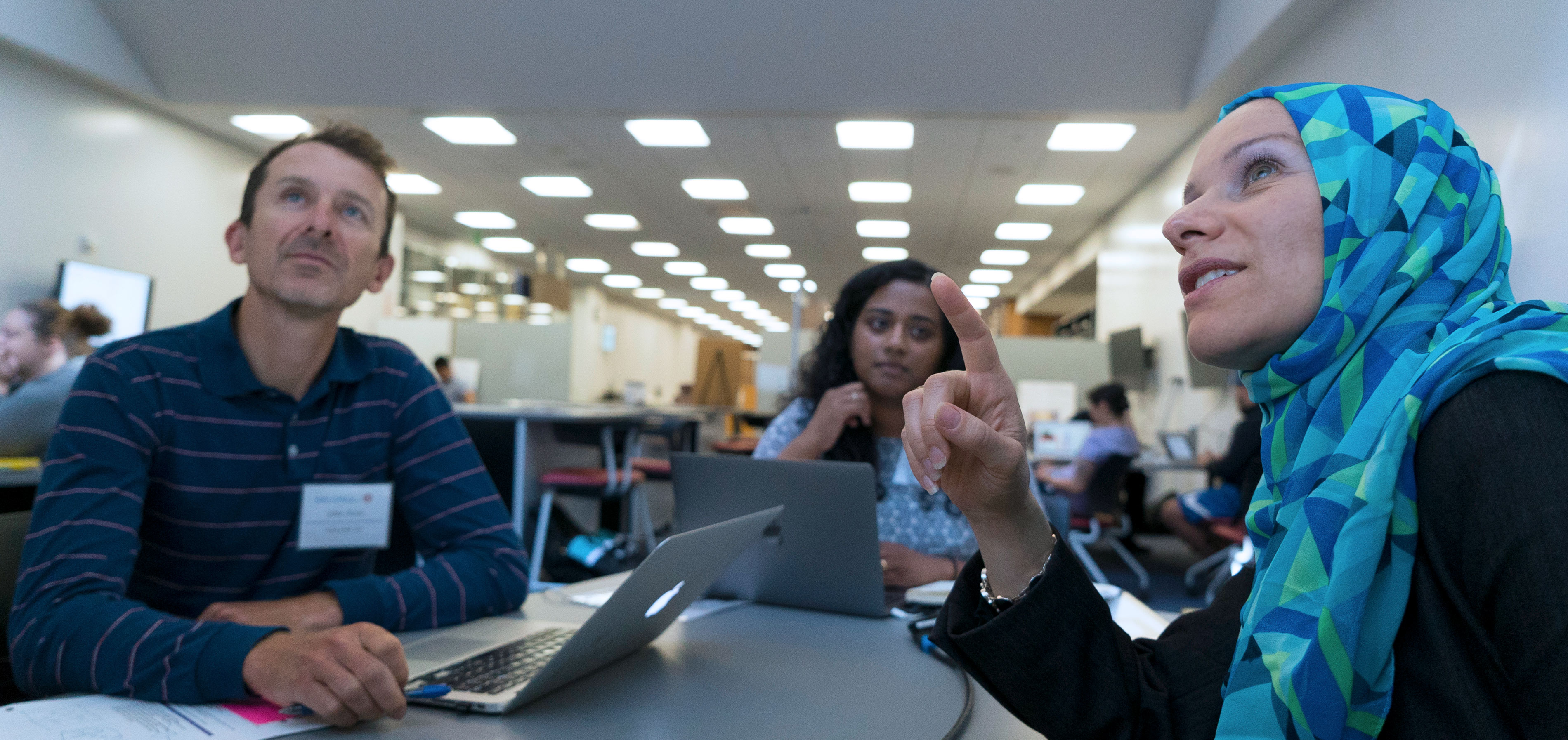 Professor pointing at the screen as her students look on.