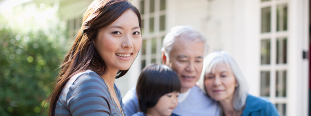 An Asian woman in the forground with a child and an older man and woman in the background.