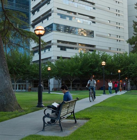 SJSU students, faculty and staff traverse campus in front of Dr. Martin Luther King Jr. Library.