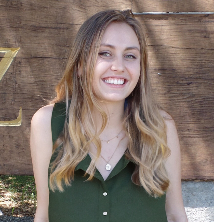 Portrait of Jessica Short with wood fence in background.