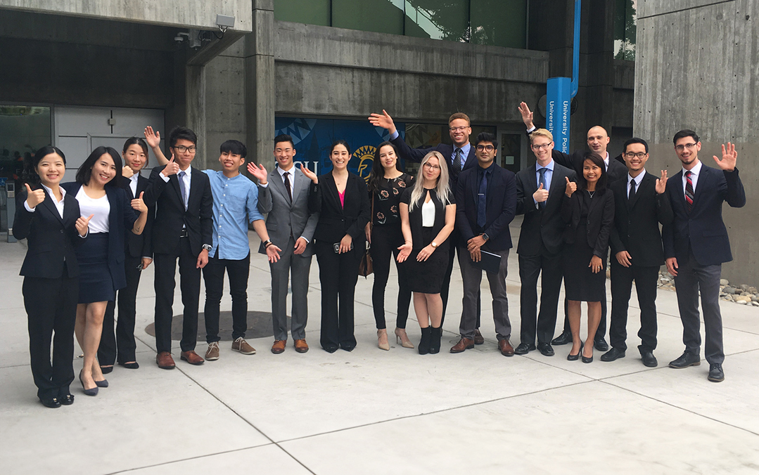 Business students in suits gather together on campus.