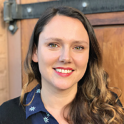 Alena Sauzade smiling in blue collared shirt.