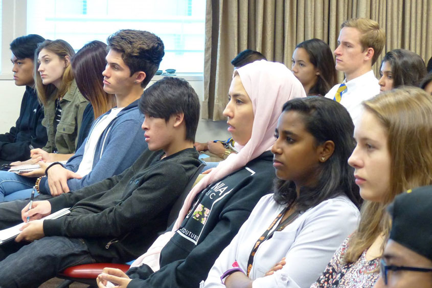 A crowd of students sit and listen during constitution day.