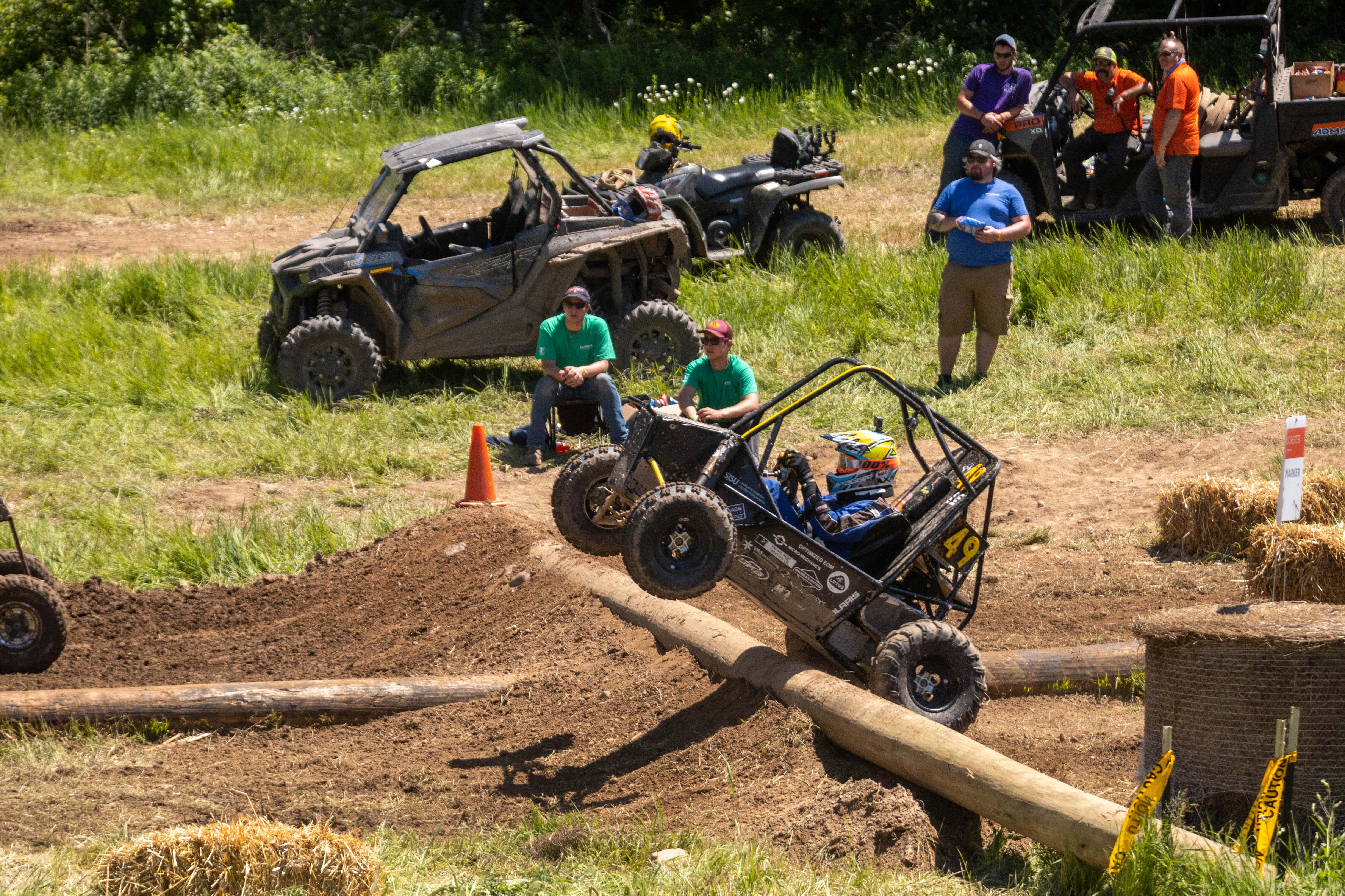 SJSU Baja buggy on the cusp of riding off of a dirt ramp