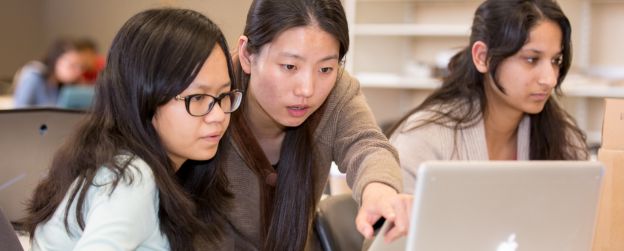 Students looking at a computer screen and pointing out something