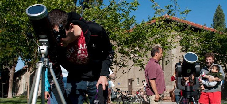 Male student looks into a telescope.