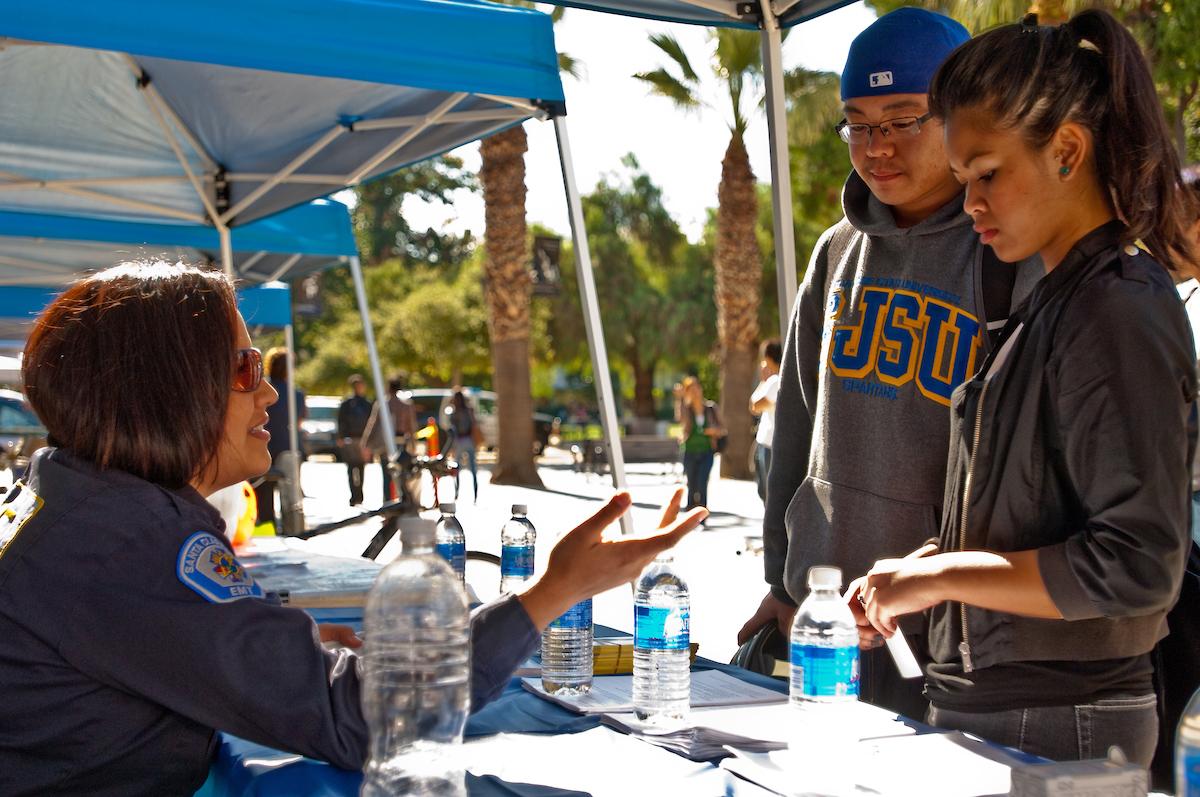 University police officer assists a male and female student with information.