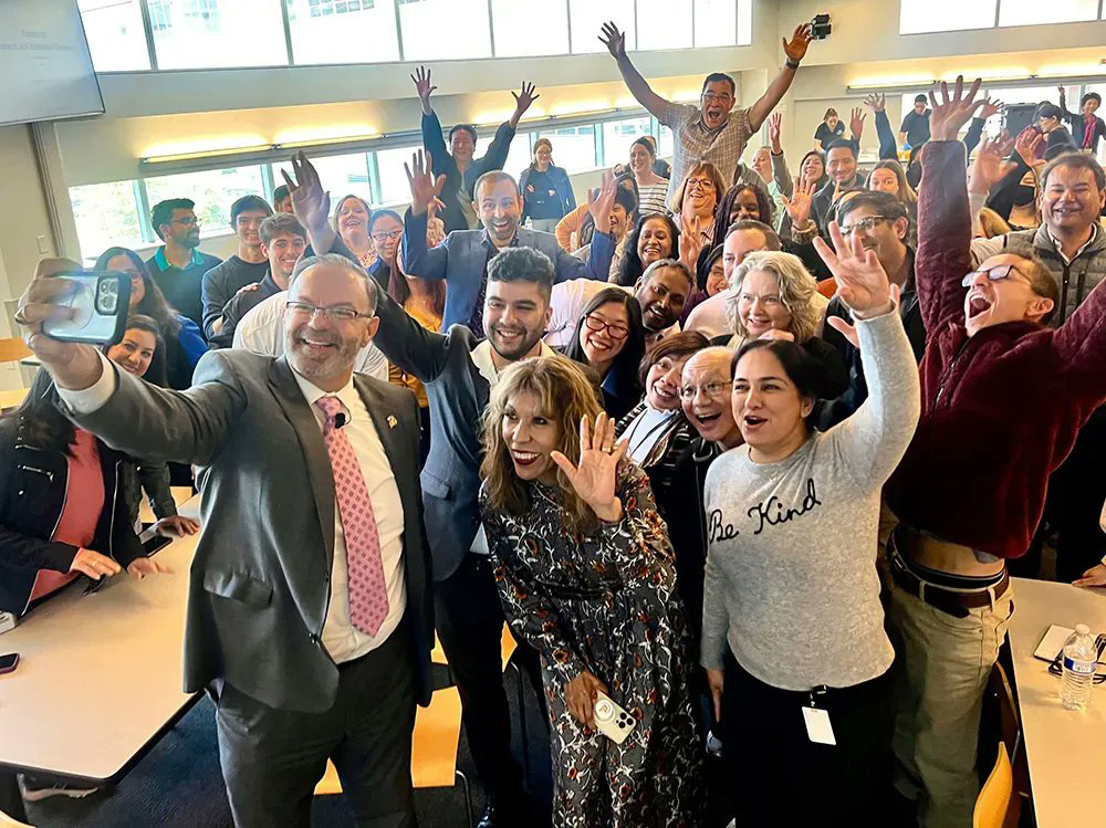 The president taking a selfie with the division of research and innovation.