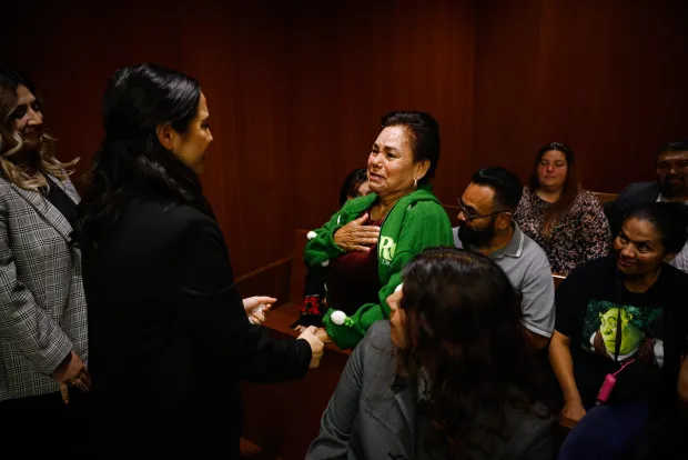 Adriana Vazquez-Chavez, a student assistant with the Record Clearance Project, holds hands before embracing Carmen Navarro, whose son was cleared of past convictions, at Family Justice Center in San Jose.