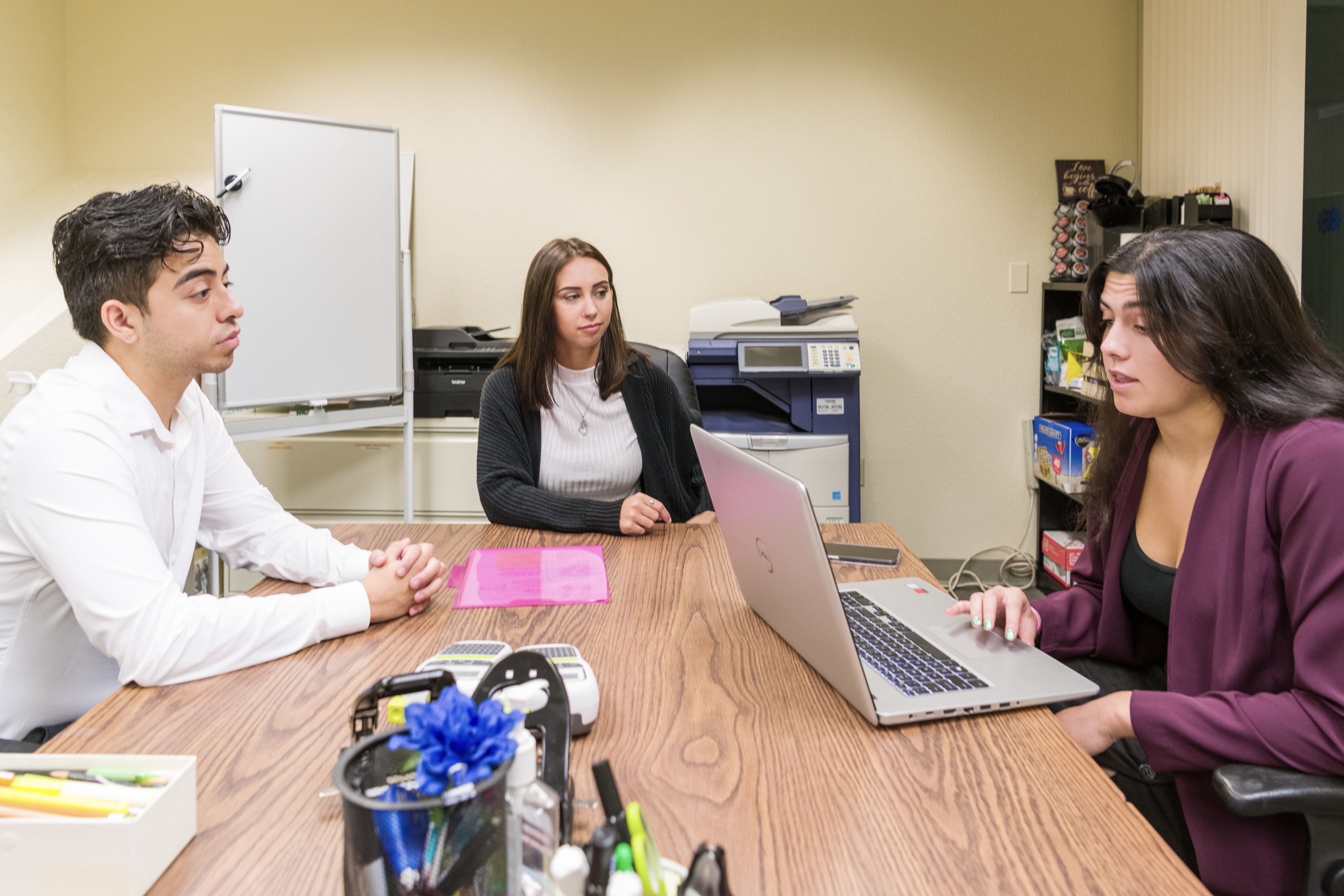 Students sitting in an office with open laptops