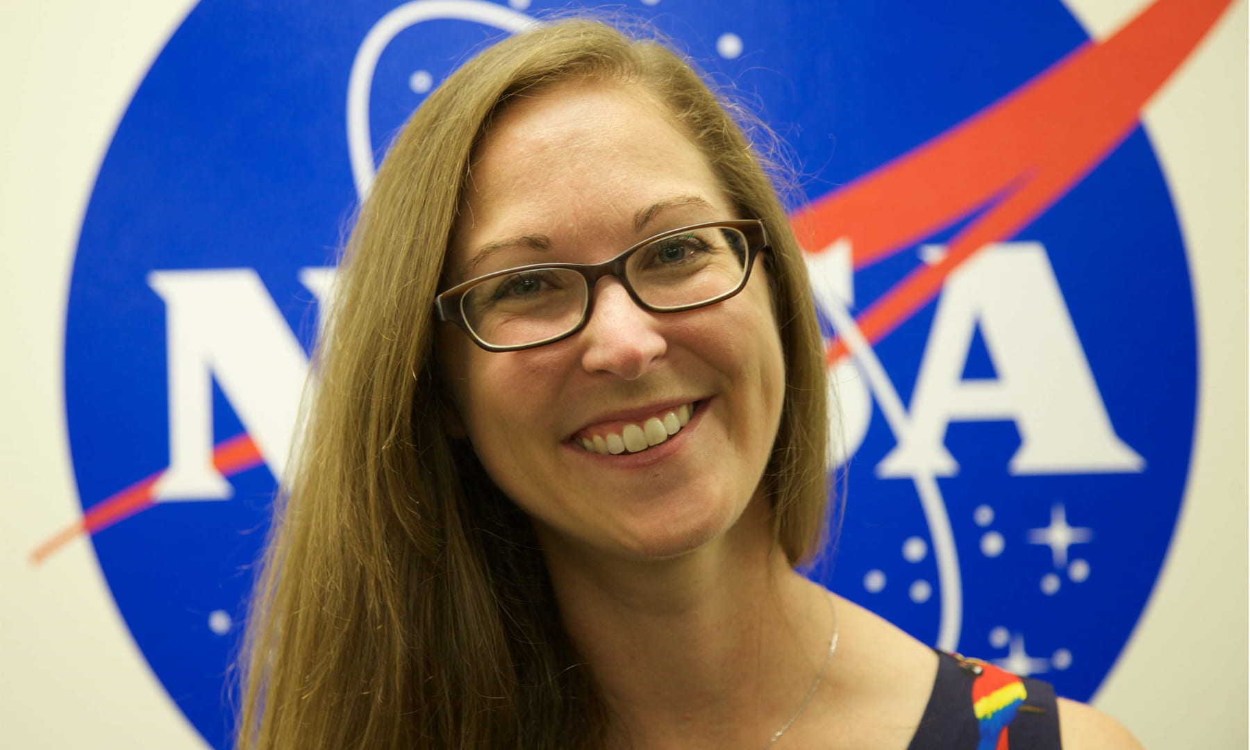 Cassie Hilditch headshot with NASA logo in the background