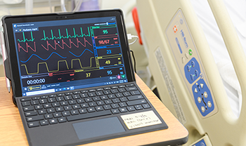 health monitor showing heart/medical information near hospital bed