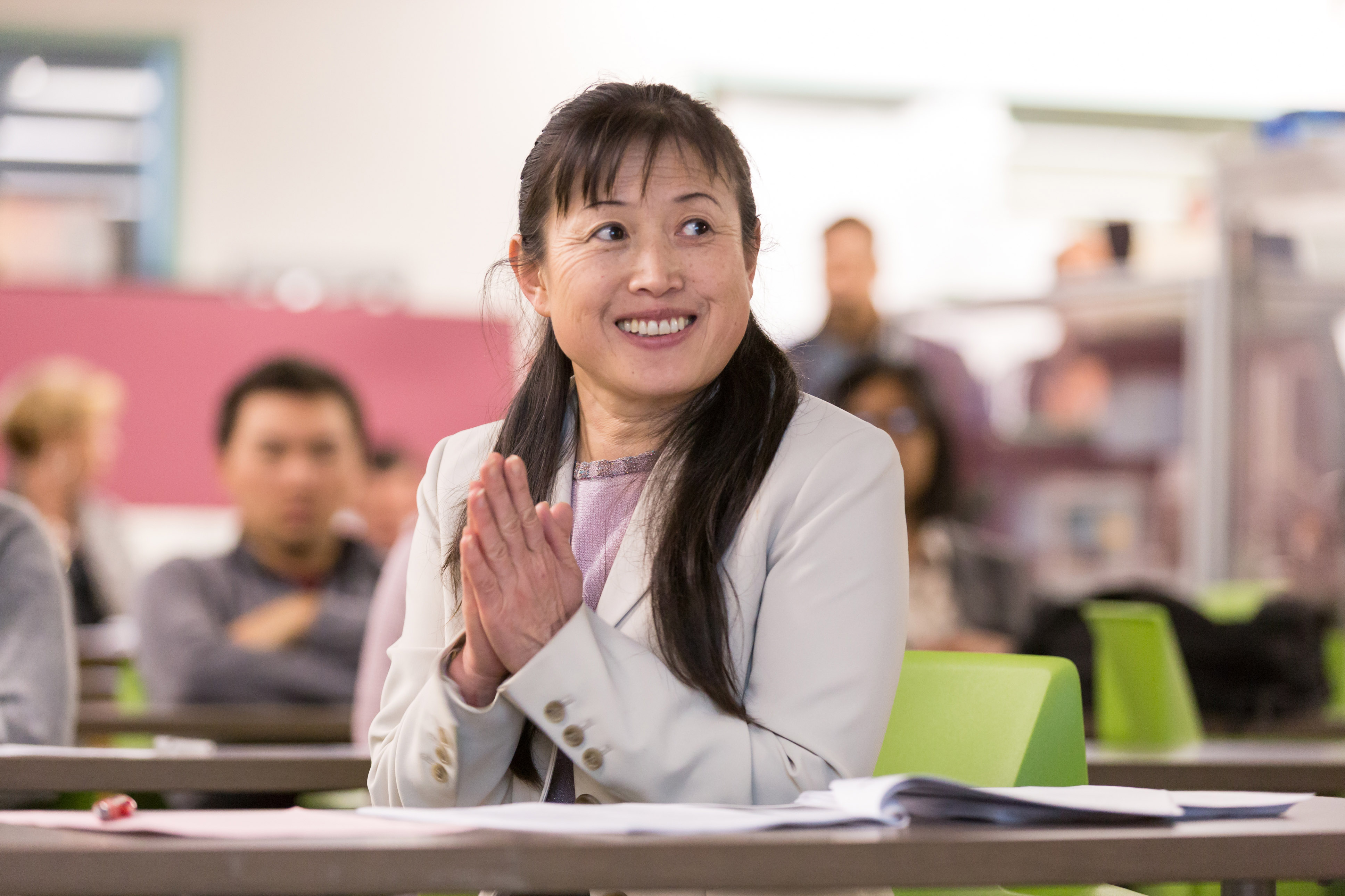 Female student applauding during lecture,