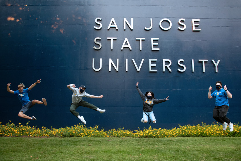 students outside SJSU signage