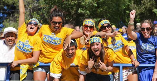 Group of students wearing SJSU merchandise cheers enthusiastically.